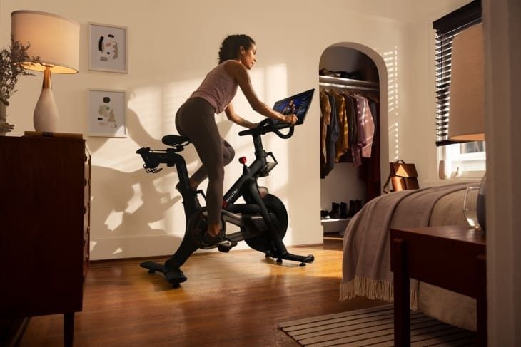 Person tränar på motionscykel i ett ljust sovrum